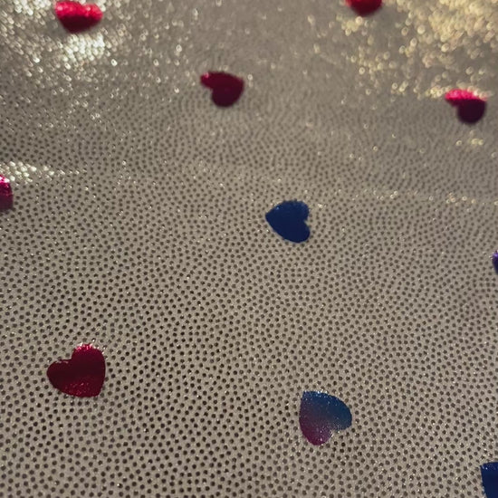 Video of metallic silver fabric with multicolored metallic hearts.